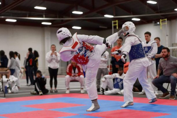 Omer Fahri Onder kicking an opponent at the MIT taekwondo competition