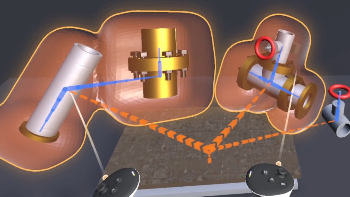VR view of pipe parts staged on a wooden pallet. A gray pipe and a brass flanged pipe, joined by a solid blue line, share one glowing orange hull, and a T-pipe with a red valve wheel sits in a second hull at right. Dashed orange lines run from the pallet to the gray pipe, the T-pipe and a small valve, and two controllers point at the gray pipe and the T-pipe.